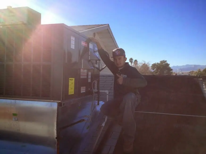 HVAC technician performing HVAC Inspection on a rooftop unit in Aurora